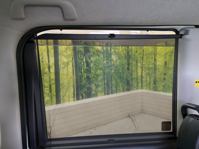 【リアロールサンシェード】後部ドアにはサンシェードを装備。強い日差しをシャットアウト。快適にドライブを楽しめます。ロール式なので使わないときにはスッキリ収納。