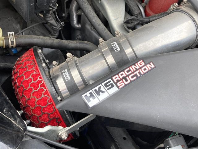 【HKSレーシングサクション】純正のフレキシブルゴムホースをアルミ製パイピングへ変更することで吸入効率を向上。アクセルを踏み込みたくなる吸気音♪